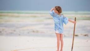 Adorable little girl on beach vacation having fun